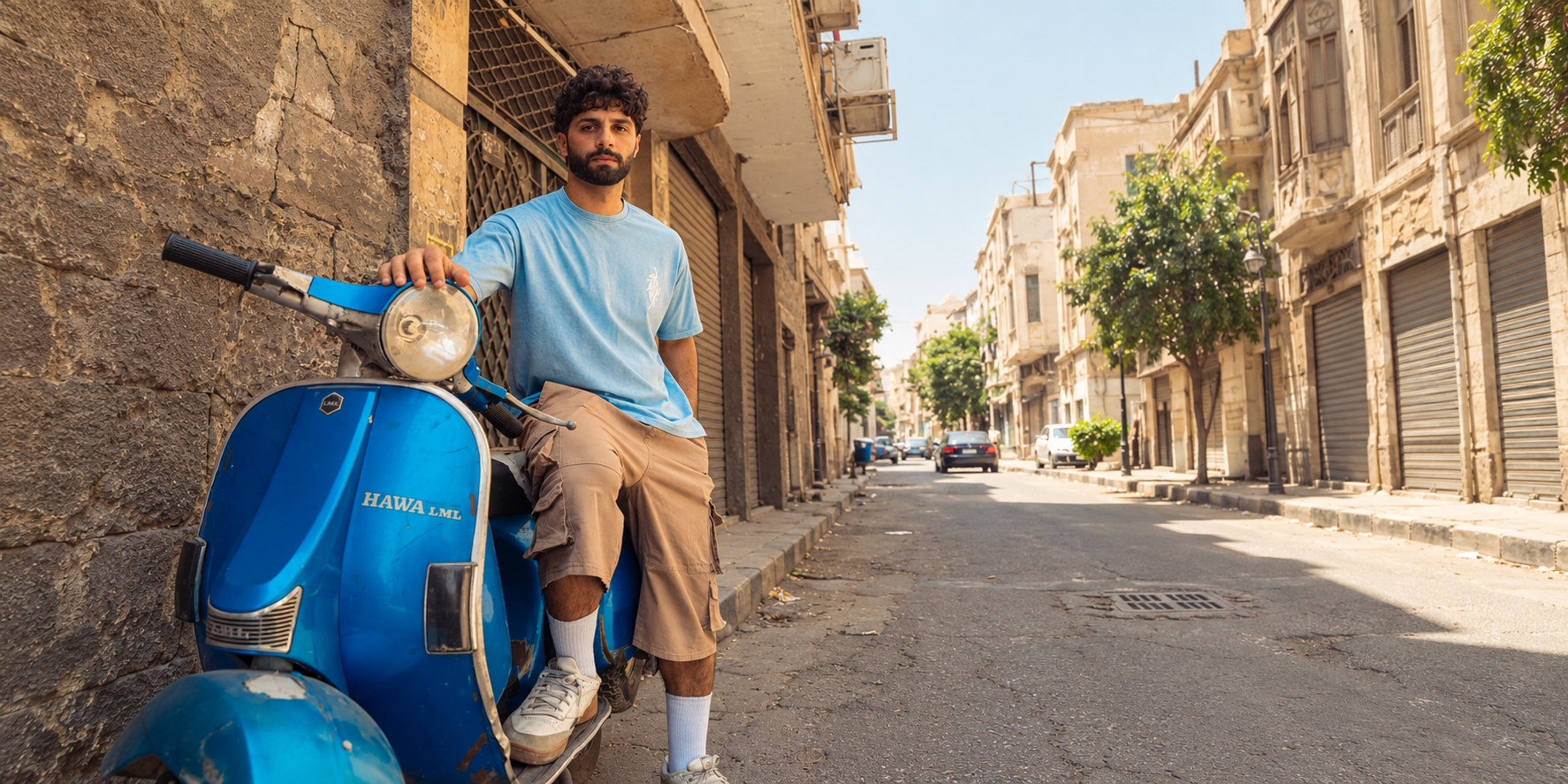 Stabraq blue tee and beige cargo shorts beside a blue scooter in Cairo