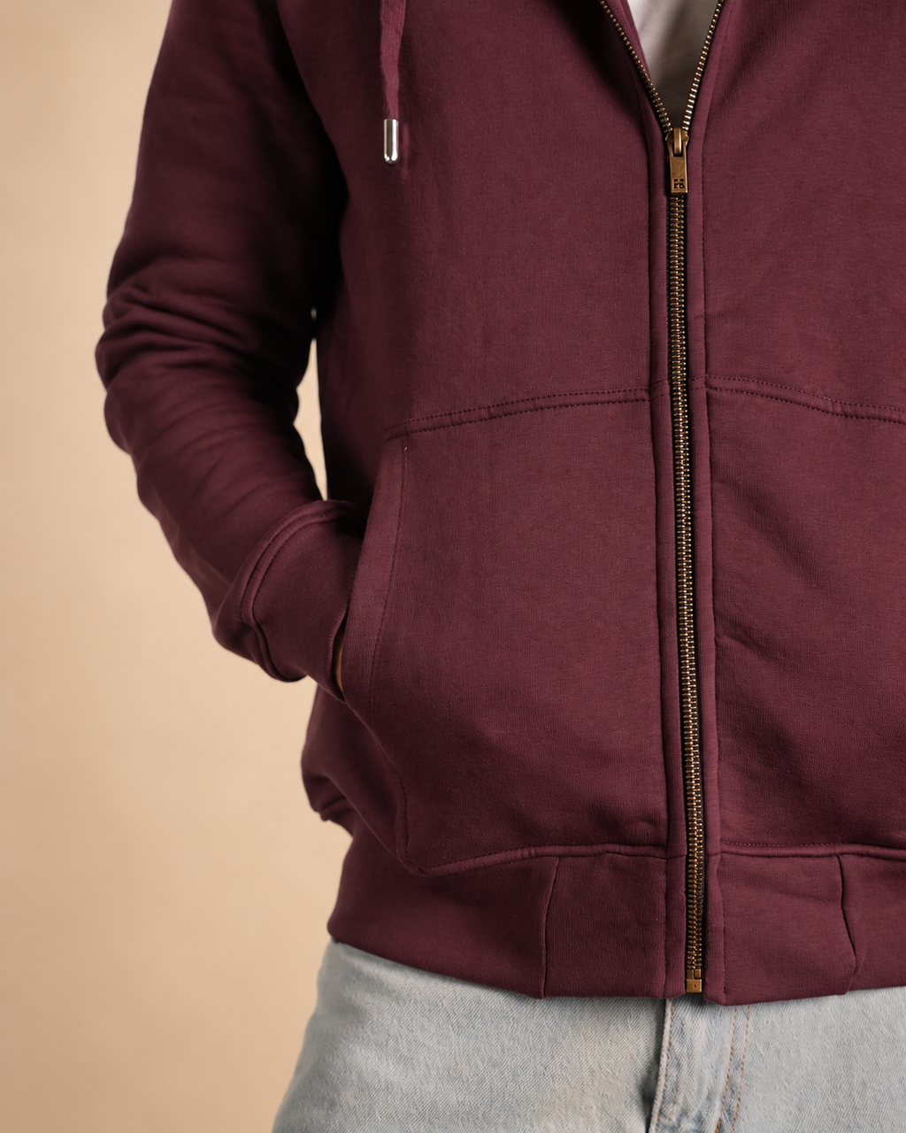 Stabraq High Neck Melton Zipper in burgundy, close-up of the pocket, cuff and lower zipper on a beige studio background