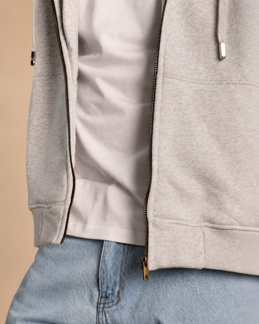 Stabraq High Neck Melton Zipper in heather gray, close-up of the open zipper, pockets and hem on a beige studio background