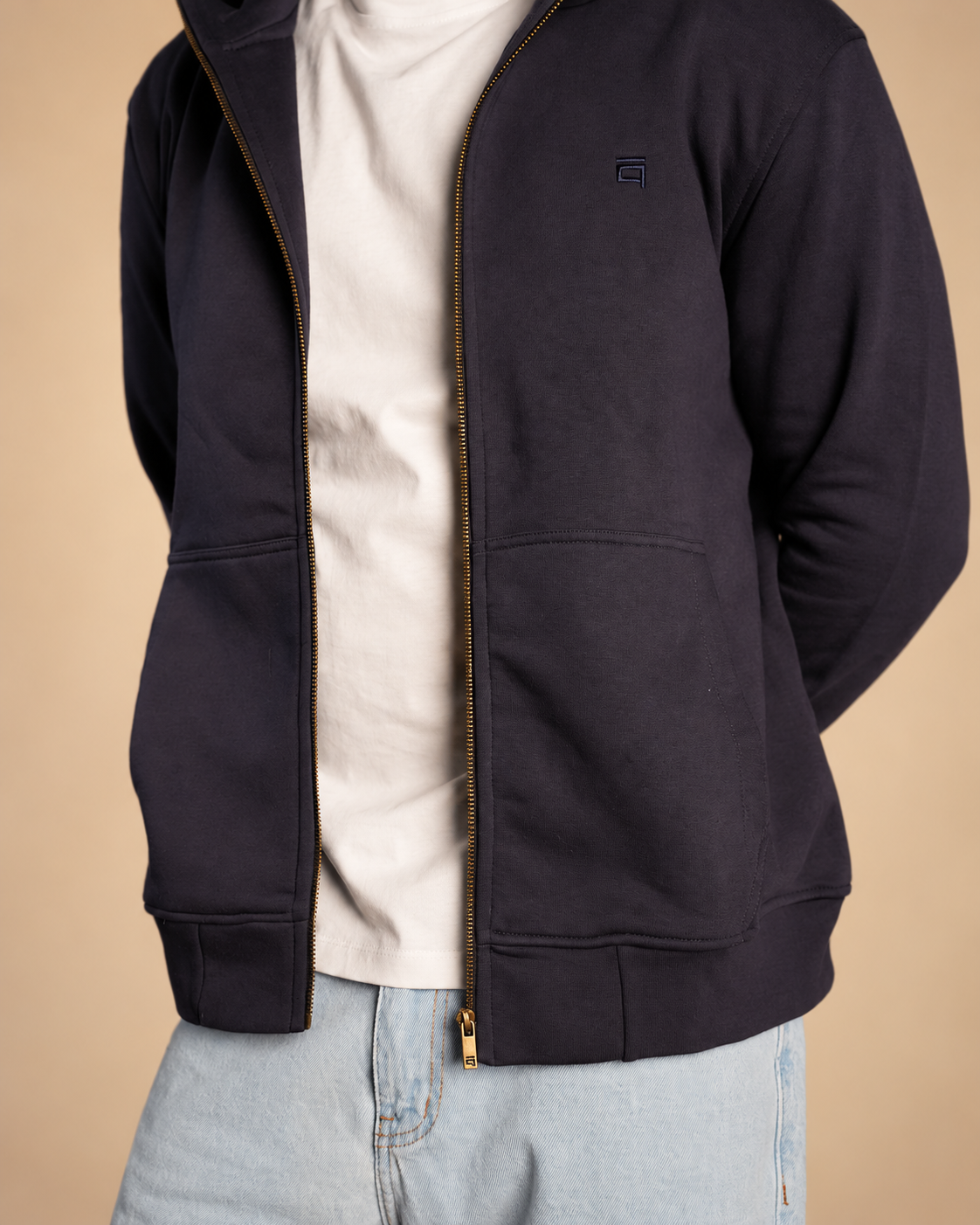 Stabraq High Neck Melton Zipper in navy blue, close-up of the torso, pockets and hem on a beige studio background