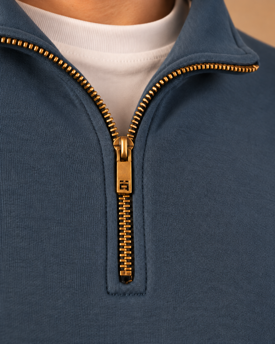 Stabraq Indigo Quarter Zipper, tight close-up of collar, zipper and fabric on a beige studio background