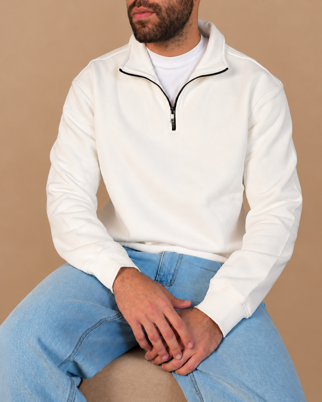Stabraq Off White Quarter Zipper, seated upper-body view with lower-face crop on a beige studio background