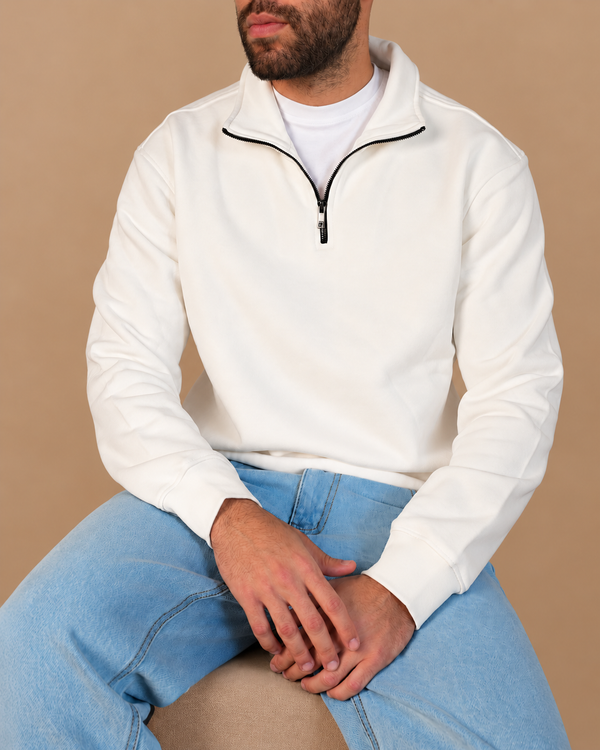 Stabraq Off White Quarter Zipper, seated upper-body view with lower-face crop on a beige studio background