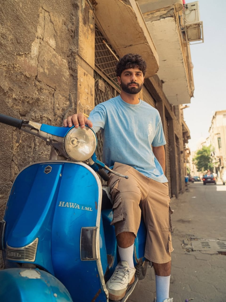 Stabraq blue T-shirt and beige cargo shorts photographed with a blue scooter