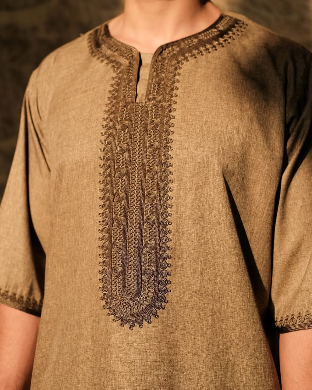 Close-up of the original embroidery and texture of a brown Stabraq thawb